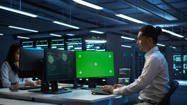 Şirket güvenlik duvarını hacklemek ve hassas kullanıcı verilerini çalmak için yeşil ekran bilgisayar kullanan bir mühendis. İşçi model bilgisayara bakıyor, güvenlik ihlali bildirimi görüyor, kamera B