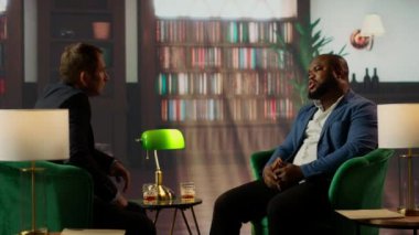 Kendine güvenen beyefendiler klasik bir kulüpte buluşup viski içerek pazarlık ediyorlar. Başarılı bir işbirliği ve karşılıklı saygıyı vurguluyorlar. Milyarderler cemiyeti. Kamera B.