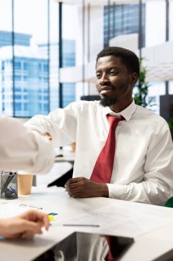 İnsan Kaynakları çalışanı mutlu adayı inceliyor, nitelikler hakkında sorular sorduktan sonra tokalaşıyor. İş fırsatı için beceri ve coşkuyu kanıtladıktan sonra röportaj kapanış anlaşmasında neşeli başvuru sahibi