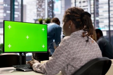 Kadın yönetici krom anahtar ekranın yanındaki finansal planlamaya odaklanarak veri analizi ve şirket stratejisi için bilgi grafiklerini gözden geçirdi. İş kadını büyümeye yönelik girişimsel çözümler sunuyor.