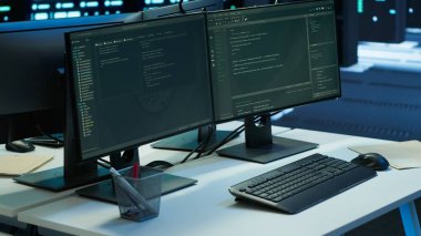 Altyapı raflarını yönetmek için kullanılan ağ sistemli veri merkezi işyeri. Ekipmanları denetlemek için kullanılan gelişmiş sunucu merkezindeki masadaki bilgisayar ekranları