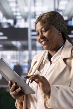 Mutlu CEO, ofisteki iş gelirlerinin grafiklerine ve diyagramlarına baktıktan sonra memnun oldu. Elektronik cihazın finansal istatistiklerini inceleyen neşeli bir yönetici, stratejik anlayışlar bulmaya çalışıyor.