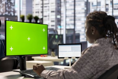 Çalışma alanında oturan kadın yönetici, stratejik iş hedefleri ve karar verme süreçlerini desteklemek için mali raporları analiz ediyor..