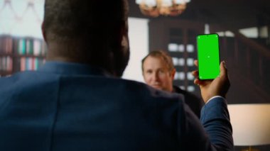 Çeşitli personel CIA 'in güvenli evindeki ahşap bir kütüphanede yeşil ekran teknolojisi ve istihbarat analizini harmanlayarak belgeleri inceliyor. Kritik görev detayları hakkında birbirimize brifing veriyorduk. Kamera A.