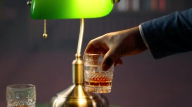 Seçkin üst sınıf beyefendiler lüks bir sosyal kulüpte tütsülenmiş viski içip sofistike para yaşam tarzı ve eğlencesini sergiliyorlar. Kapatın. Kamera A.