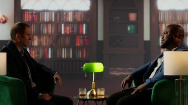 Sosyal kulüp toplantısında stratejik sohbete katılan, viski içen ve seçkin iş kültürü kavramını somutlaştıran kendinden emin varisler. Üst sınıf sosyete. Kamera B.