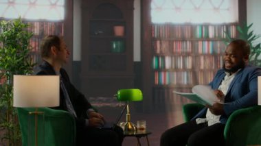 Gizli servis görevlileri viski bardaklarıyla gizli belgeleri inceliyor klasik bir güvenli ev kütüphanesinde buluşuyorlar. Ajanlar gizli görev detaylarına odaklanıyor. Kamera A.