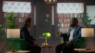 Şık bir kütüphanedeki işadamları viski, güven, başarı ve seçkin sosyal çevrelerin lüksünü yansıtan ortak hedefleri tartışırlar. Üst sınıf sosyete üyeleri kulüpte buluşuyor. Kamera A.