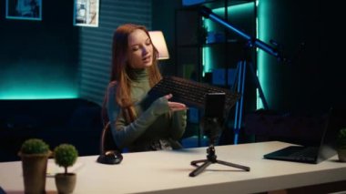 Marka sponsorluğu videosundan klavye sunan bir kadın hayranlarına satın almalarını tavsiye ediyor. Genç çevrimiçi yıldız, bilgisayar reklamından hayran kitlesi B kamerasına etki ediyor.