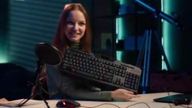 Fiyatın haklı olup olmadığını görmek için kişisel stüdyoda gözden geçirirken klavye ve fareyi test eden Happy 'nin etkisi. Seyircilere bilgisayar çevresi özellikleri gösteren neşeli medya yıldızı, kamera A