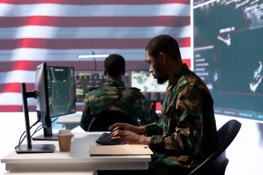 Askeri personelden oluşan bir ekip, yüksek teknolojili bir komuta merkezinden gözetleme ve güvenlik operasyonlarını yönetir..
