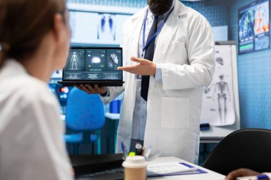 Doktor, sağlık personeliyle yaptığı toplantıda kalp ve beyin analizleri için tomografi sonuçlarını sunuyor. Dizüstü bilgisayardaki elektrokardiyogram testlerini inceliyor. Lisanslı sağlık görevlileri kurtarma planını tartıştılar.