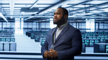 Sistem yöneticisi veri merkezindeki hologramlara bakıyor, ekipmanları izliyor. Sunucu çiftliğindeki çalışan, gelecekteki artırılmış gerçeklik yapay zekası ile etkileşimde, kamera A