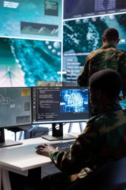 Görev kontrol merkezindeki askeri uzmanlar uydu görüntüleri ve verileri analiz etmek için bilgisayar ve büyük ekran üzerinde modern teknoloji kullanıyorlar. Uzman istihbarat operasyonları için potansiyel tehditleri izliyor.