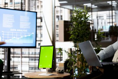 Yöneticinin yanındaki yeşil ekran tableti işletme verimliliğini ve karlılığını artırmak için iş stratejileri uyguluyor. Şirket yöneticisinin yanında Chroma anahtar aygıtı gelir hedefleri belirliyor