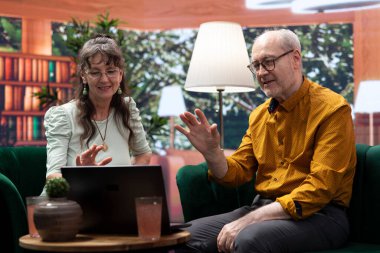 Elderly man and woman waving at grandchildren on online videocall, maintaining the long distance relationship with the family. Old people enjoying retirement, using internet connection. clipart