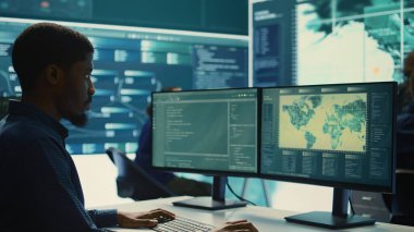 Siber güvenlik uzmanları bir devlet dairesinde şifreleme ve bilişim güvenliği üzerinde çalışıyor. Ulusal güvenlik için siber operasyonlar, ağ güvenliği ve veri koruması üzerinde çalışan uzmanlar. Kamera B.