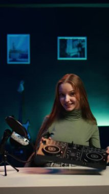 Dikey video genç sanatçısı DJ 'i daire stüdyosunda karışık özel ders verirken çeker ve ses kontrolöründen örnekler gösterir. Happy Entertainer, yaşayan abonelere modern müzik ekipmanları gösteriyor.