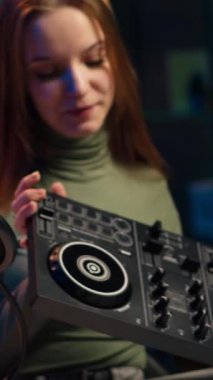 Dikey video genç sanatçısı DJ 'i daire stüdyosunda karışık özel ders verirken çeker ve ses kontrolöründen örnekler gösterir. Happy Entertainer, yaşayan abonelere modern müzik ekipmanları gösteriyor.