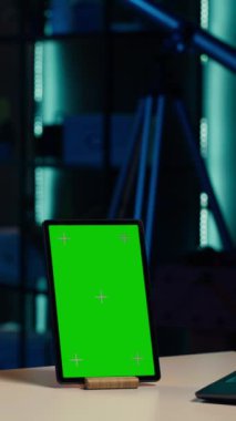 Gülümseyen genç internet yıldızı markalı sponsorluk videosundan yeşil ekran model tableti sunuyor. Krom anahtar izole ekran aygıtı reklamları ile kız etkili pazarlama yapar