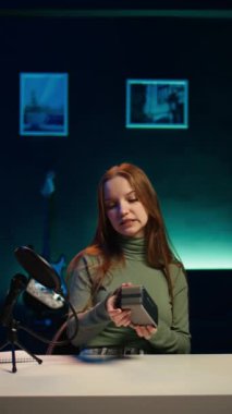 Dikey video Gen Z medya yıldızı yılın en iyi bluetooth müzik cihazları hakkında video çekiyor. Mutlu genç teknoloji içeriği yaratıcısı taşınabilir hoparlör incelemesi kaydediyor, ses kalitesini değerlendiriyor