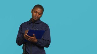 İzinsiz girenleri tahliye etmekle görevli güvenlik görevlisinin portresi yasal protokolleri takip ederken. Devriye aracı güvenli bir ortam sağlıyor, stüdyo arka planı, kamera A