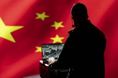 Çin casusluk bölümü casusu. Düşmanın yerini tespit etmek için dizüstü bilgisayardaki keşif yazılımını kullanıyor. Kontrol odasındaki gizli hükümet ajanı uydu aygıtı kullanarak Çin bayrağı üzerinde izole edildi.