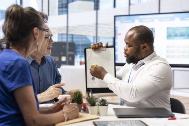 Tasarruf, yatırım ve rahat bir gelecek sağlamak amacıyla ayrıntılı bir emeklilik planı oluşturmak üzere bir mali danışmana danışan yaşlı çift. Hayat sigortası ve finans.