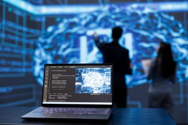 Bulanık arka planda mühendisler tarafından yapay zeka hesaplamasını kullanmak için kullanılan dizüstü bilgisayara odaklan. Bilgisayardaki yapay zeka teknolojisini çalıştırmak için IT profesyonelleri tarafından kullanılan defterin yakın plan görüntüsü.