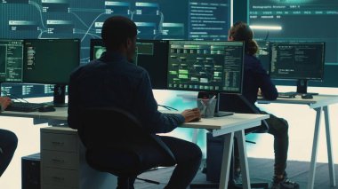 Hükümetin hackleme odasındaki uzmanlardan oluşan siber istihbarat ekibi ulusal sırları korumanın yollarını arıyor. Dijital güvenlik, siber gözetim ve siber terörizmin önlenmesi. Kamera A.