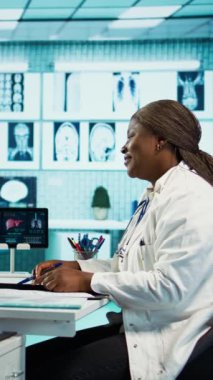 Tekerlekli sandalyedeki bir doktor ve hasta arasındaki dikey video medikal etkileşimi, teşhis koyarak, etkili bir sağlık hizmeti tavsiyesi ve tedavisi için geri bildirim. Maluliyet dostu ofis. Kamera B.