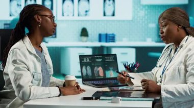 Profesyonel tıbbi danışmanlık, teşhis sonuçlarını inceleyen bir kadın doktor ve hastayı gösteriyor, sağlık güvenini ve sağlığın hassasiyetini arttırıyor. Siyah kadınlar check-up 'ta. Kamera A.