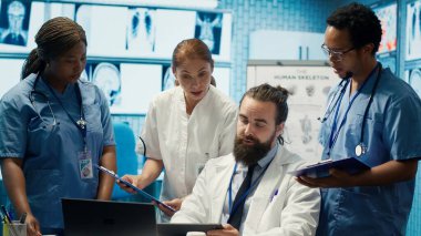 Sağlık uzmanları tedavi planları, takım çalışması ve radyoloji uzmanlığı geliştirmek için insan anatomisi taramalarını inceliyor. Tıp uzmanları özel klinikte analitik üzerinde çalışıyorlar. Kamera A.