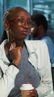 Dikey video Afrikalı Amerikalı kız boğaz ağrısı ve bronşiyal iltihaptan muzdarip, otolaryngologla grip haplarını tartışıyor. Yutkunma rahatsızlığı ve acı veren hastalığı olan bir hasta.