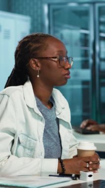 Dikey görüntülü akciğer enfeksiyonu olan genç bir kız doktor tavsiyesi istiyor öksürük ve nefes almada yardımcı olması için tıbbı tartışıyor. Afrikalı Amerikalı hasta ve doktor klinikte