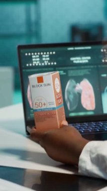 Dikey video hekimi yaz boyunca cilt bakımı sırasında siyahi bir kıza harika bir cilt bakımı sunarak, ekstra koruma için spf 50 ile birlikte güneş kremi öneriyor. UV kalkan nemlendiricisi