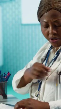 Dikey video uzmanı bir erkek hastayla konuşuyor, teşhis teknolojisi ve tıbbi tavsiyeleri birleştiriyor. Sıhhiye, genç bir adamla sağlık için etkileşim halinde. Kamera A