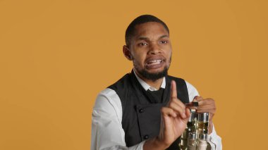 Catering staff asking clients to wait a minute before getting their order, trying to serve people as fast as he can. Waiter working at a busy restaurant, putting customers on hold. Camera A. clipart