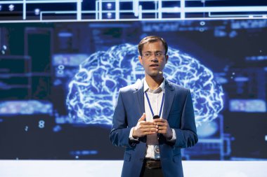 CEO, AI teknolojilerinin konferans sırasında iş sektöründe verimliliği ve yeniliği nasıl artırabileceğini sunuyor. İş adamı yapay zeka güdümlü çözümlerin uygulanmasından bahsediyor