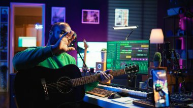 Yetenekli bir sanatçı, yeni başlayanlara tavsiye vermek üzere internet ana sınıfına online olarak akustik gitar çalmayı öğretiyor. Dizgilerle akorları açıklayan sanatçı bestecisi. Kamera B.