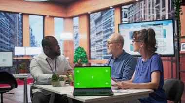 Yaşlı müşteriler danışmanıyla emeklilik planının güvenliğini tartışıyor, modern ofiste dizüstü bilgisayarlarında kroma anahtarı var. Yaşlılar hayat sigortası için emeklilik seçeneği sunuyor. Kamera B.