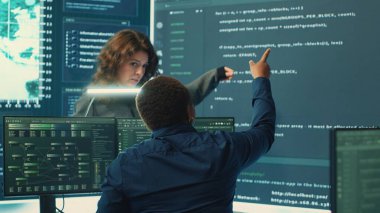 Siber güvenlik uzmanları bir devlet dairesinde şifreleme ve bilişim güvenliği üzerinde çalışıyor. Ulusal güvenlik için siber operasyonlar, ağ güvenliği ve veri koruması üzerinde çalışan uzmanlar. Kamera A.