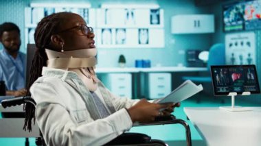 Boynunda kırık bir boyun yarası olan tekerlekli sandalye kullanıcısı. Servikal köpük tasma takıyor. Ağrı kesiciler ya da iyileşme tavsiyeleri hakkında uzmanla konuşuyor. Muayene sırasında omurga kırığı olan genç bir kız. Kamera B.