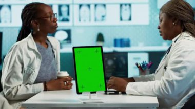 Afro-Amerikalı doktor ve hasta yeşil ekranın yanında iyileşme planını tartışıyor, check-up sırasında buluşuyorlar. Sağlık ve sağlık hizmetleri konusunda uzman genç bir kıza danışıyorum. Kamera A.