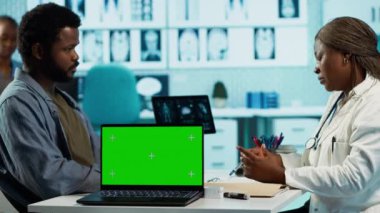 Afro-Amerikalı genç bir adam, sağlık uzmanına mankenin yanındaki tavsiyeyi soruyor, sağlık kontrolünde tıbbi kayıtları birlikte analiz ediyor. Hasta bir hastayla doktor toplantısı. Kamera A.