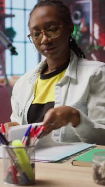 Merkez ofisteki dikey video muhasebecisi dizüstü bilgisayardaki mali raporları inceliyor ve bilgi yazıyor. Dairede telgraf işçisi defterdeki belgeleri okuyor ve kağıda kalemle notlar alıyor.