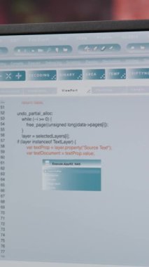 Merkez ofisteki dikey video mühendisi bilgisayar monitöründe UI 'ye bakıyor, programlama kodunu yazıyor ve çalıştırıyor. Modern apartmanda kod yazmak ve test etmek için kodlama uygulaması kullanan kişiyi kapat