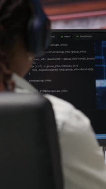 Dikey video bilişim mühendisi kahve içiyor, evdeki bilgisayarı yapay zeka hesaplaması için kullanıyor. Masaüstü bilgisayarı B 'deki yapay zeka derin sinir ağları ile çalışan uzak işçiyi kapat