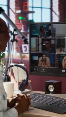 Merkez ofisteki dikey video kumanda çalışanı çevrimiçi video görüşmesi sırasında meslektaşlarını selamlıyor, bilgisayar ekranına bakıyor. Video konferansında apartman çalışanlarını karşılayan iş kadını, kamera.