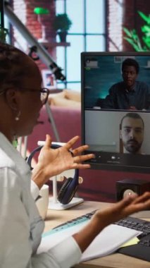 Dikey video yönetmeni, video görüşmesi sırasında çalışanları karşılıyor, evrakları inceliyor, iş vardiyalarını düzenliyor. Denetmen, personelle uzaktan telekonferans toplantısı yapıyor.